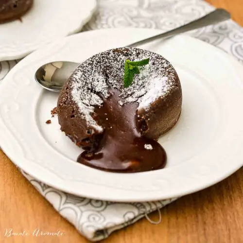 Lava cake cald, cu miez lichid de ciocolată, presărat cu zahăr pudră și frunze de mentă