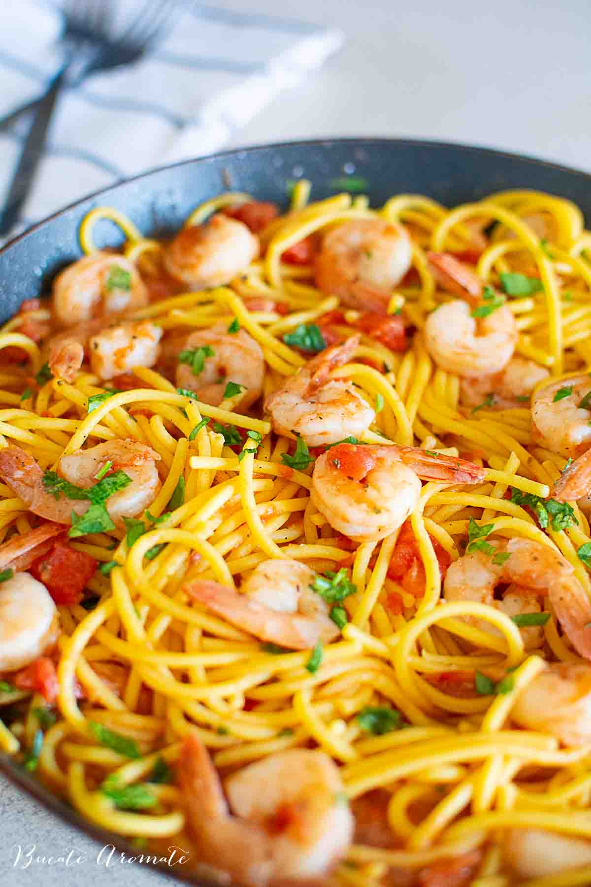 Rețetă de spaghete cu creveți și sos de roșii servită caldă, în tigaie