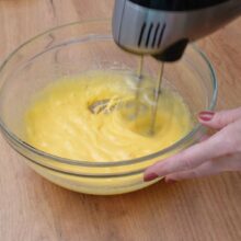 Gălbenușurile și zahărul bătute spumos cu mixerul pentru crema de bază.