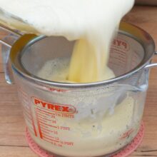 Strecurarea compoziției finale de cremă prin sită fină pentru o textură perfect netedă.