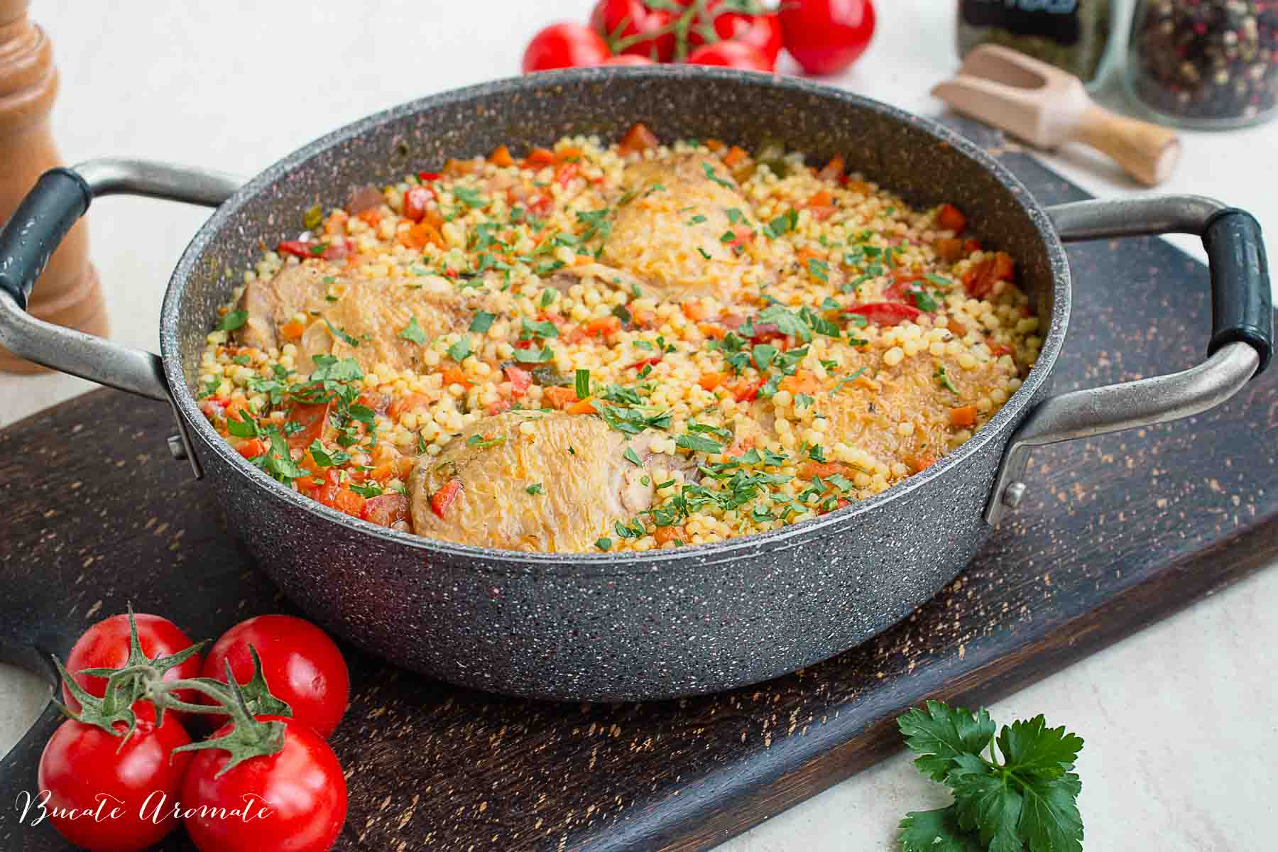 Cușcuș cu legume și carne de pui gătit complet, presărat cu pătrunjel verde și gata de servit.
