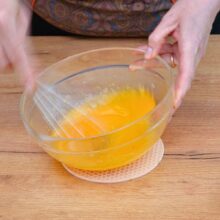 Ouă, zahăr și sare bătute cu telul într-un bol – bază pentru prăjitura lava cake