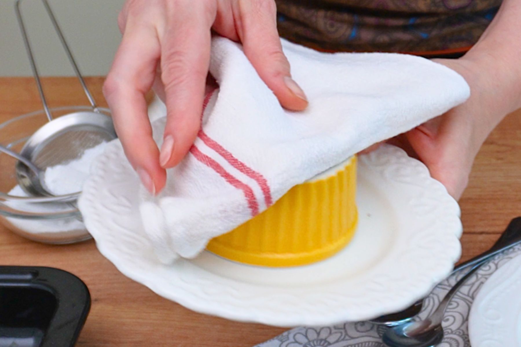 Formă ramekin răsturnată pe farfurie cu ajutorul unui prosop – scoaterea lava cake-ului după coacere