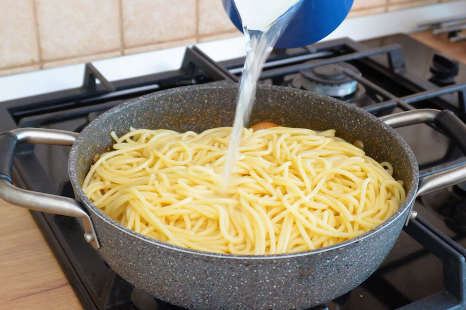 Spaghete fierte adăugate peste creveți și sos de roșii pentru o rețetă rapidă de paste