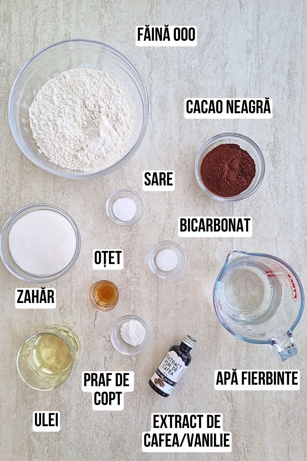 Ingrediente pentru blat de post cu cacao: făină 000, cacao neagră, zahăr, sare, bicarbonat, praf de copt, ulei, oțet, apă fierbinte și extract de vanilie