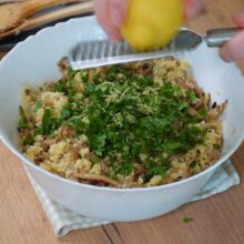 Coajă de lămâie rasă peste couscous cu ciuperci și pătrunjel – aromă proaspătă pentru o rețetă vegană