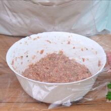 Compoziția pentru frigărui din carne tocată de pui, acoperită cu folie alimentară și lăsată la rece pentru a se întrepătrunde aromele.
