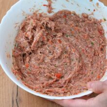 Compoziție omogenă de carne tocată, ceapă, ardei și condimente, pregătită pentru modelare pe bețe.