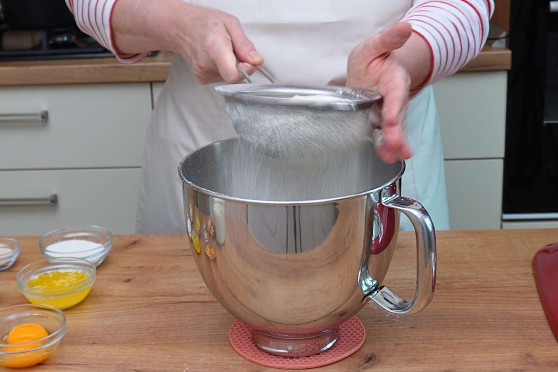 Făină cernută într-un bol mare pentru aluatul de gogoși, pas esențial pentru aerarea compoziției.