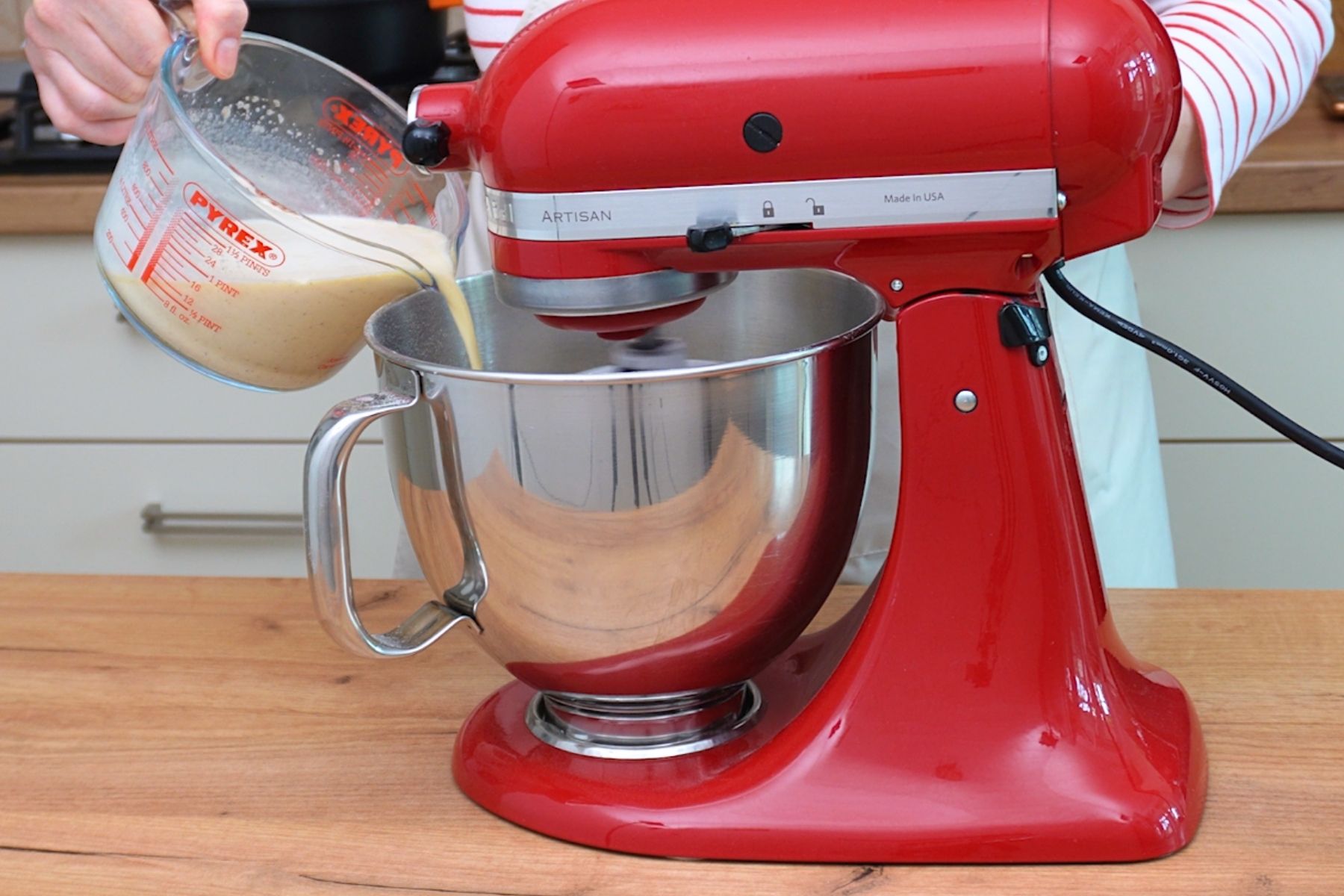 Turnarea compoziției lichide în mixer pentru a începe frământarea aluatului de gogoși.