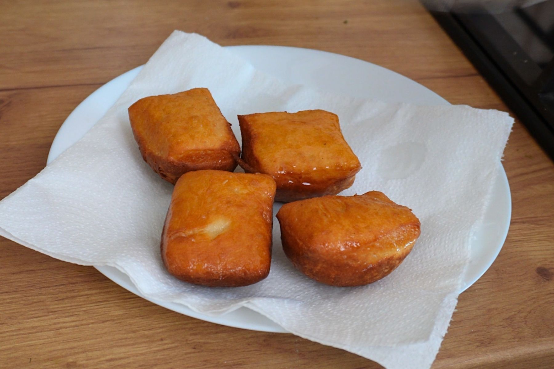 Gogoși proaspăt prăjite, așezate pe șervet absorbant pentru a elimina excesul de ulei.