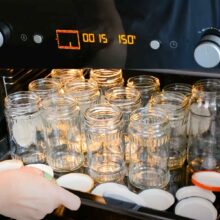 borcane și capace așezate în tava cuptorului pentru sterilizare la 150 de grade pentru 15 minute
