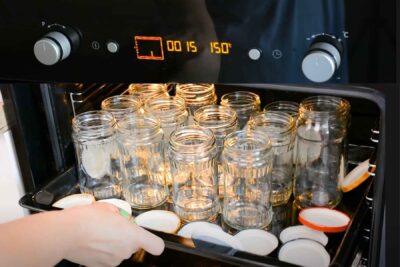 borcane și capace așezate în tava cuptorului pentru sterilizare la 150 de grade pentru 15 minute