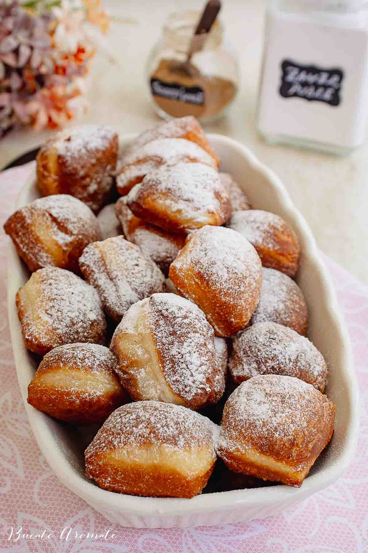 Tavă plină cu gogoși prăjite frumos rumenite, mari și moi.