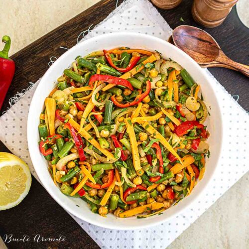 castron alb cu salata calda de naut si legume diverse morcov, ardei, ceapa decorata cu patrunjel