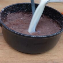 Turnați laptele peste amestecul de cacao, zahăr și amidon pentru a pregăti crema de cacao