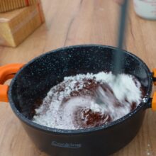 Amestecați cacaoa, zahărul și amidonul într-o cratiță pentru crema fiartă de cacao