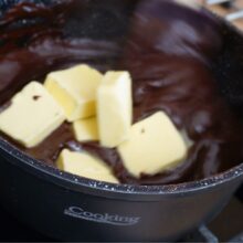 Adăugați untul în crema fiartă de cacao cât încă este caldă