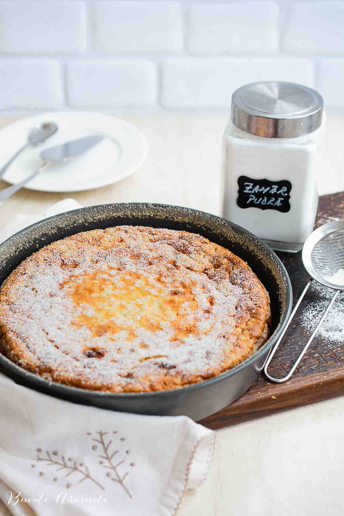 Budincă de cuscus cu brânză dulce și stafide, coaptă și pudrată cu zahăr