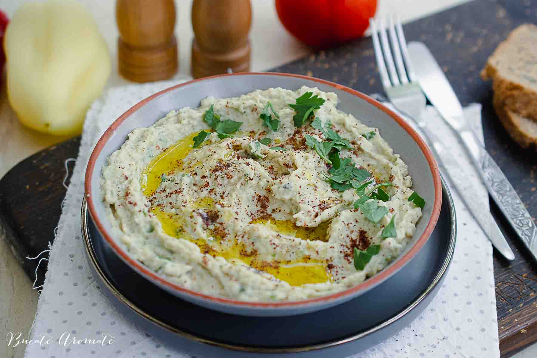 Baba Ganoush vegan, cremos și decorat cu verdeață, cu ulei de măsline și condimente orientale.