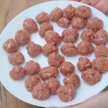 Chifteluțe crude din carne tocată de pui, modelate și gata pentru prăjit în rețeta de mâncare de mazăre cu chifteluțe