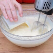 Se adaugă laptele în compoziția de ouă și zahăr pentru checul zebră, mixând cu mixerul