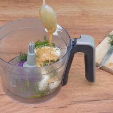 Tahini și iaurt grecesc adăugate peste dovlecei copți și mărar, pentru salată cremoasă și sănătoasă