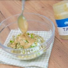 pasta de susan tahini adaugata in castron peste vinete si ceapa veede tocata pentru prepararea salatei Baba Ganoush