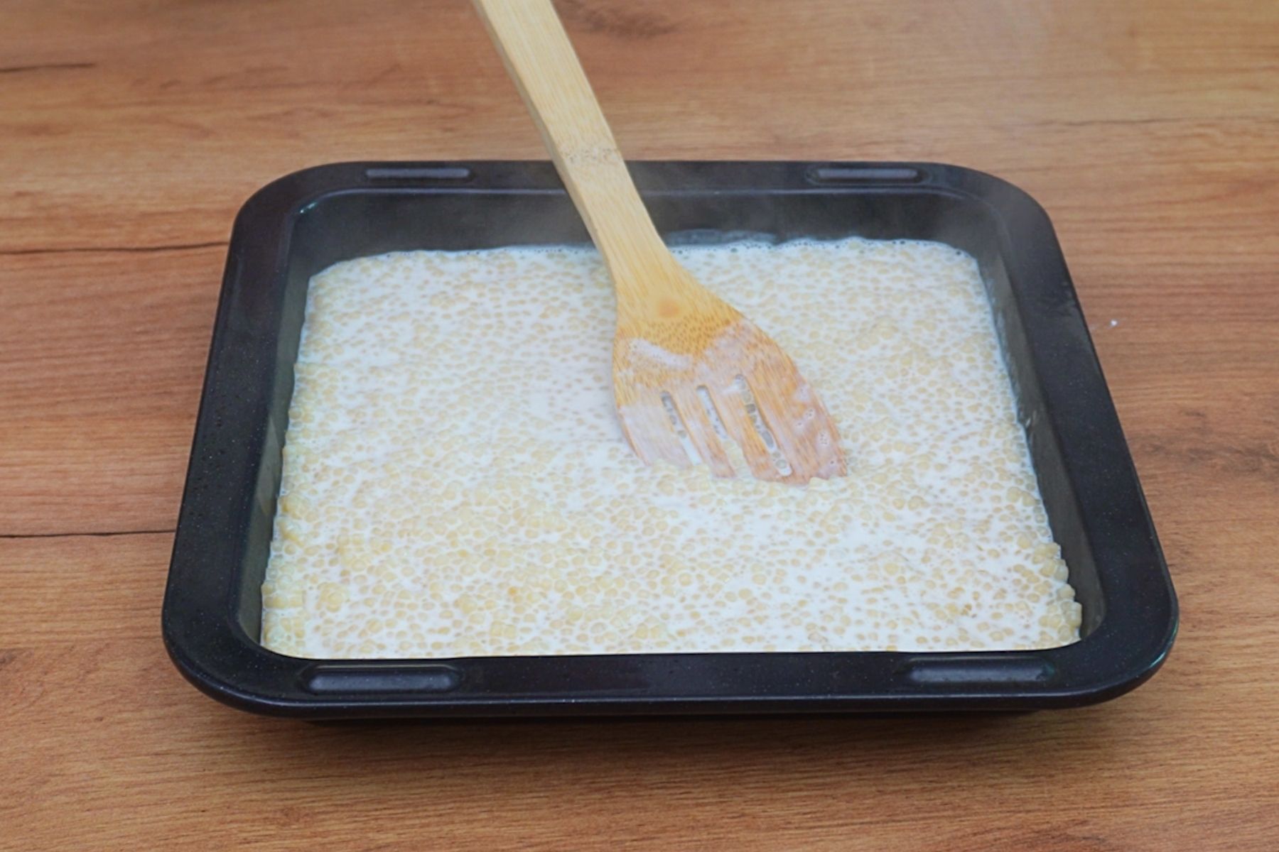 Cuscus fiert și lăsat la răcit într-o tavă înainte de preparare