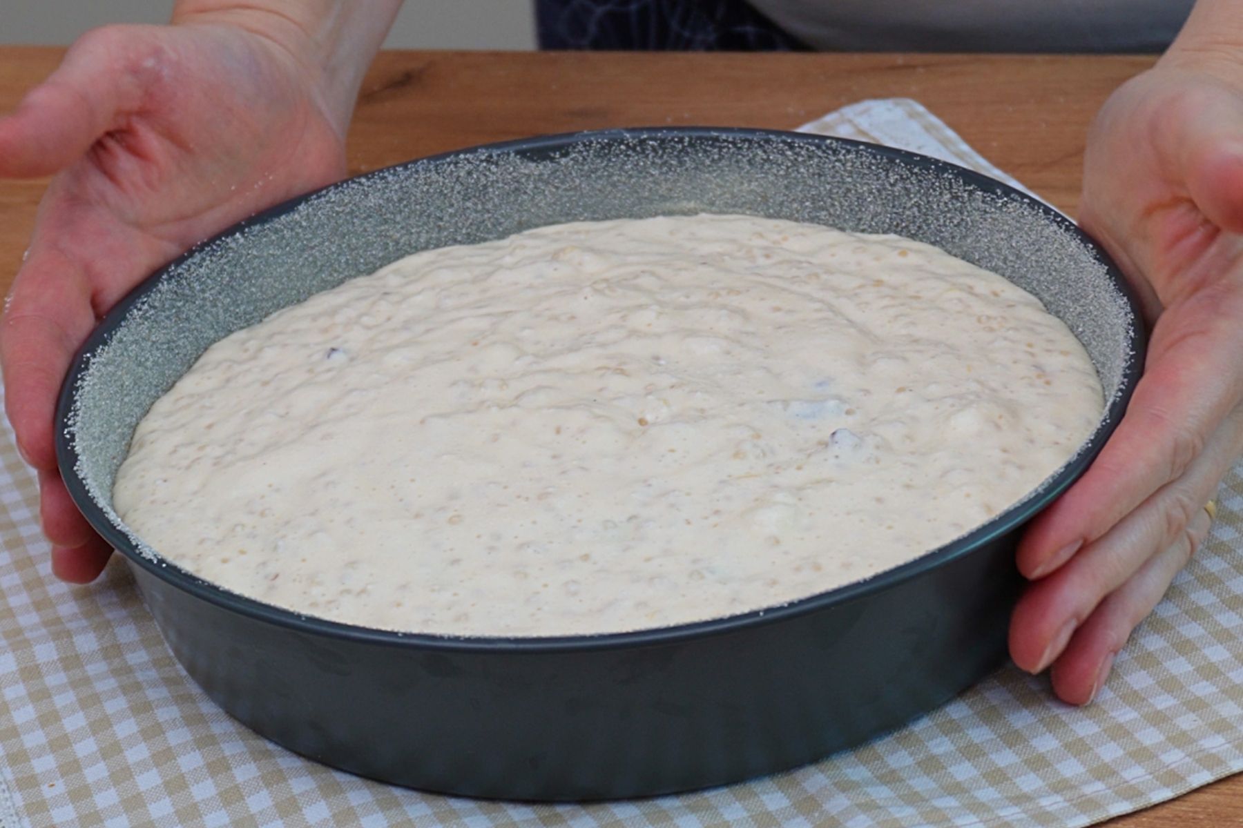 Compoziția de budincă de cuscus cu brânză turnată în tava pregătită pentru cuptor