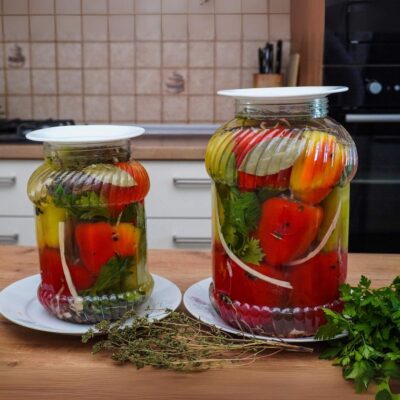 Două borcane cu ardei grași umpluți cu varză, morcov și țelină, așezați în borcane cu saramură, rețetă de murături pentru iarnă fără oțet