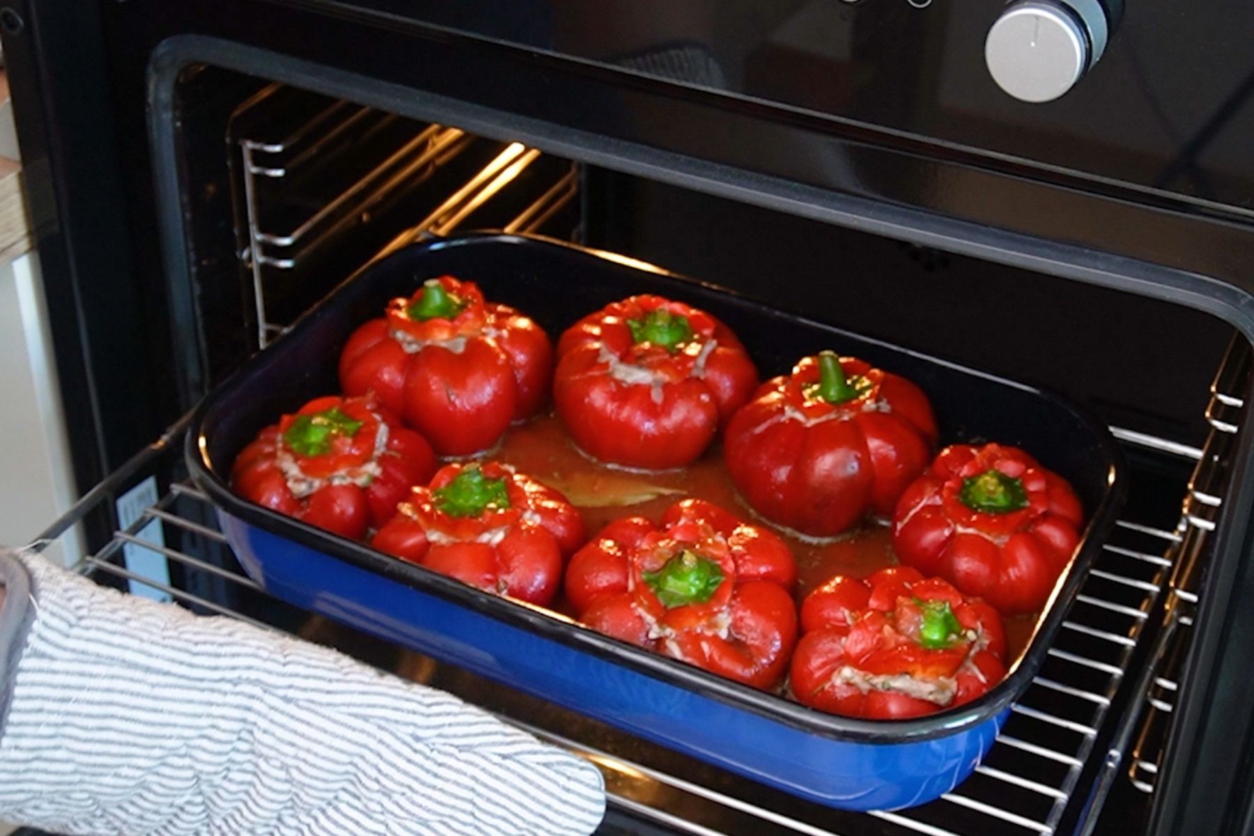 Gogoșari umpluți cu carne de pui și orez, așezați în tavă, pregătiți pentru cuptor