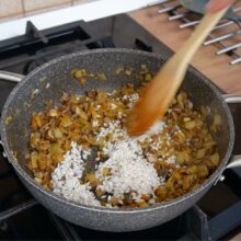 Umplutură pentru gogoșari cu legume și orez în tigaie, călită înainte de amestecarea cu carnea