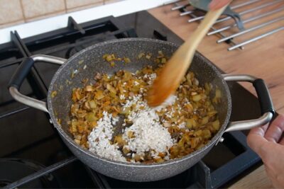 Umplutură pentru gogoșari cu legume și orez în tigaie, călită înainte de amestecarea cu carnea