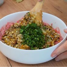 Amestecarea compoziției de carne de pui cu legume, orez și verdeață pentru umplerea gogoșarilor