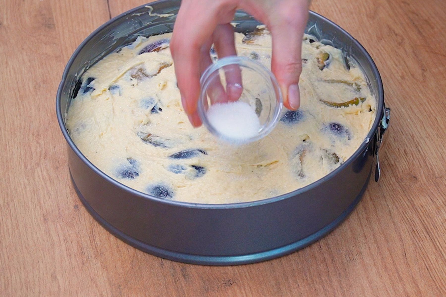 Presărare zahăr peste prăjitura cu prune înainte de coacere, pentru crustă caramelizată