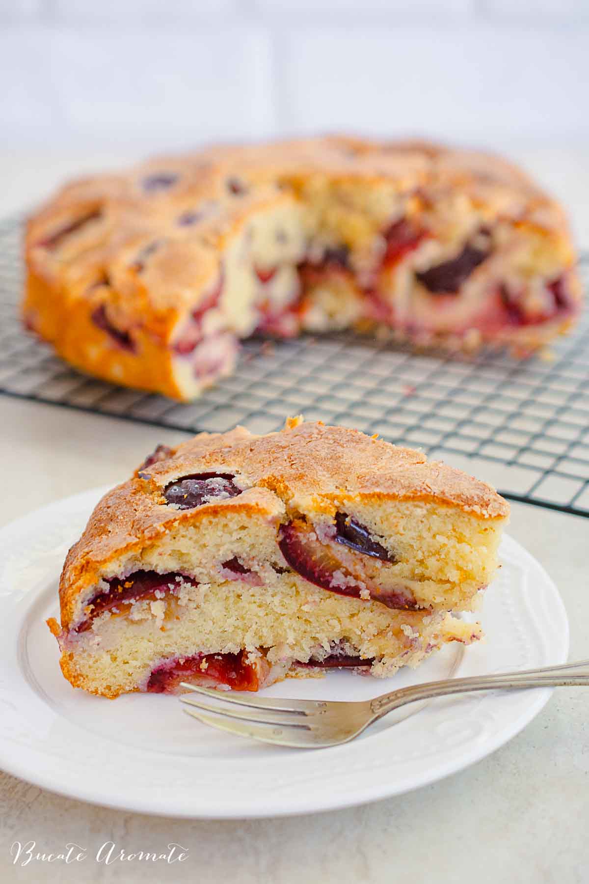 Felie din prăjitura rapidă cu prune, cu blat fraged și prune coapte în interior