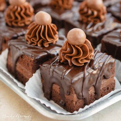 Amandine cu ciocolată decorate cu ganache și bilă de ciocolată, glazurate simplu, fără fondant, pe tavă albă