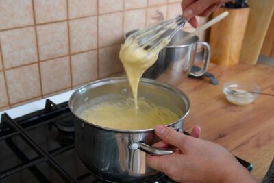 Crema de vanilie fiartă pe foc mic până se îngroașă pentru cremșnit.