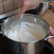 Albușuri bătute spumă încorporate în crema fierbinte de vanilie pentru cremșnit.