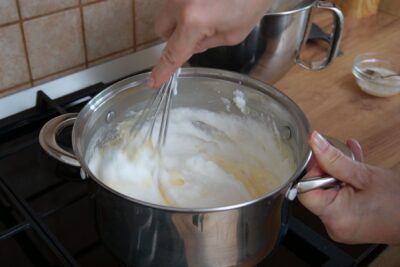 Albușuri bătute spumă încorporate în crema fierbinte de vanilie pentru cremșnit.
