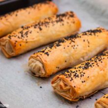 Plăcinte cu pui, ciuperci și cașcaval coapte în tavă, rumenite și presărate cu semințe de susan negru