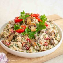 Salată ușoară cu pui, ciuperci și sos de usturoi fără ou crud, într-un bol alb pe fundal de lemn