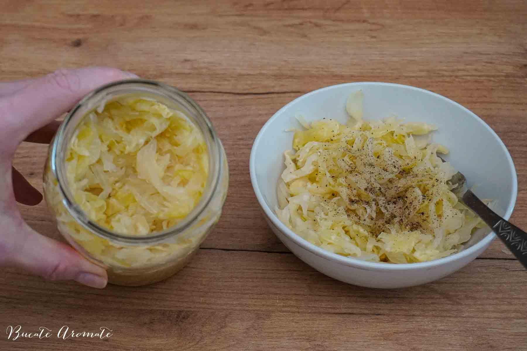 Salată de varză murată scoasă din borcan și servită cu piper și ulei