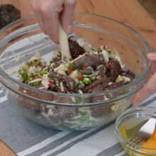 Amestecarea ingredientelor pentru chec aperitiv cu ficăței de pui, ouă, brânză și legume, într-un castron mare