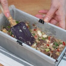 Compoziția de chec sărat cu ficăței, ouă și brânză, nivelată în tavă cu spatula înainte de coacere