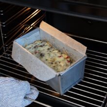 Tavă de chec cu ficăței, ouă și cașcaval în cuptor, în timpul coacerii