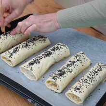 Plăcinte crude unse cu ou și presărate cu semințe, înțepate pentru a nu crăpa la copt