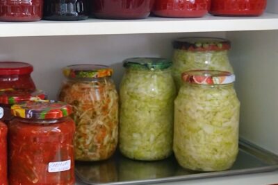 Borcane cu varză murată în suc propriu păstrate la cămară, alături de alte murături pentru iarnă.
