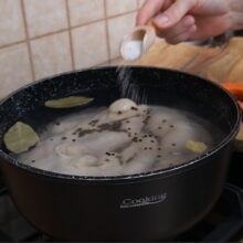 Oală cu caltaboși care fierb în apă cu sare, foi de dafin și boabe de piper – rețetă tradițională de caltaboș fără prăjeală